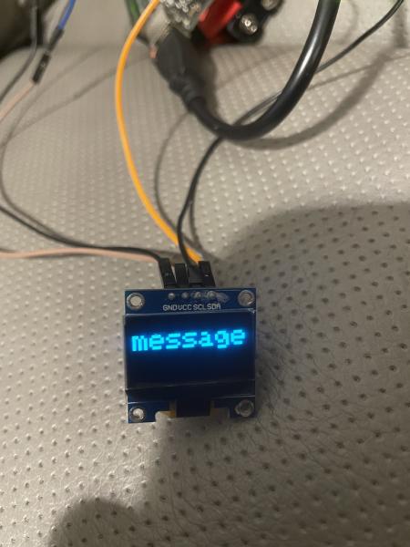 Arduino connected to OLED screen which Displays "message" (in a large font)